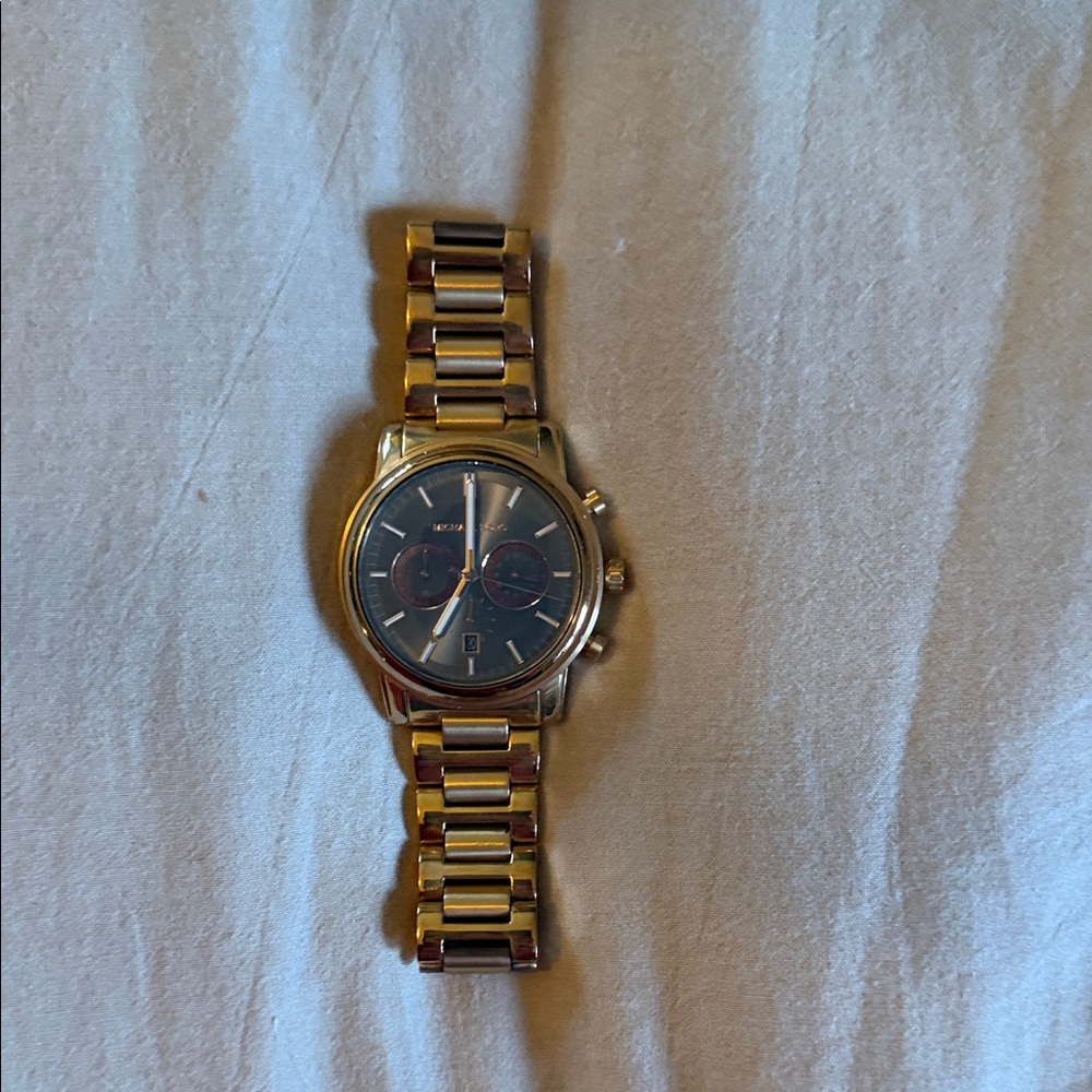 Michael Kors Gold Bracelet Watch with Gunmetal Gray  Dial and dark red accents.